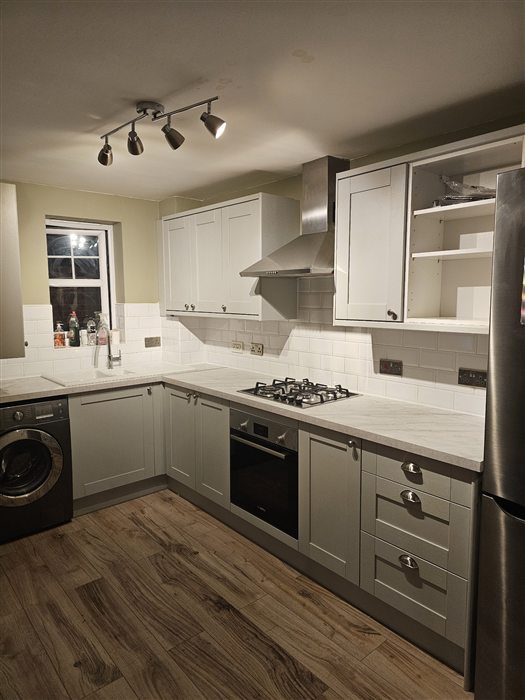 Grey shaker kitchen with white tiles and wood-effect floor