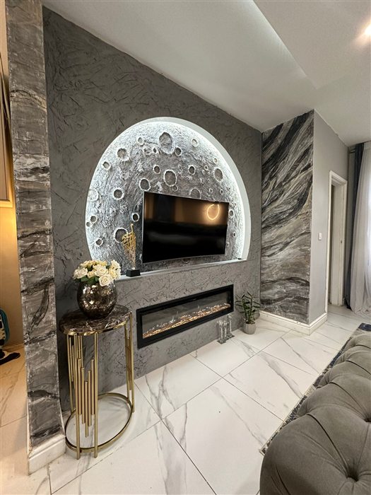Media wall with an illuminated arch and stone-effect panels
