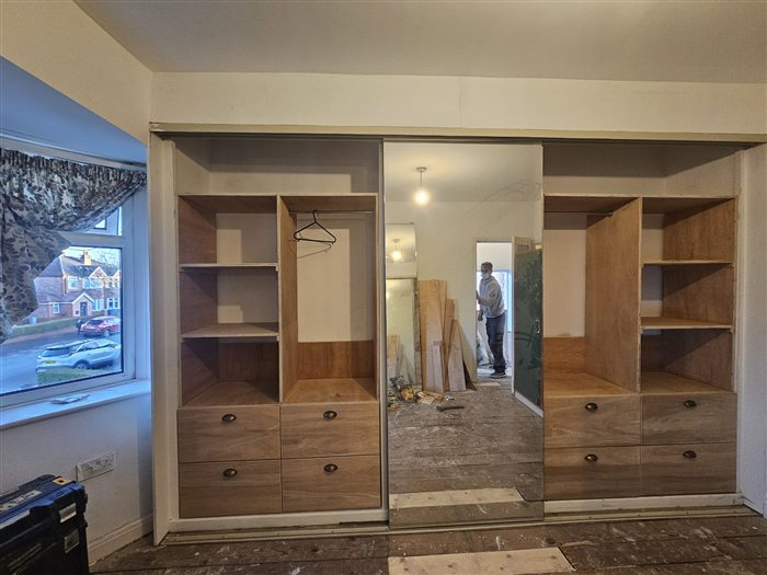 Fitted wardrobe with shelving, drawers and a mirrored sliding door
