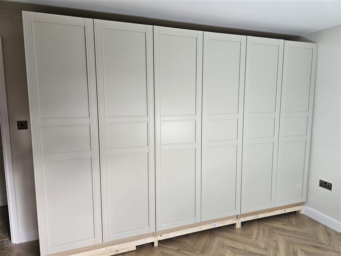Wall of white shaker fitted wardrobes